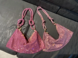 Detail view of pink and purple rhinestone crescent bags with knotted handles