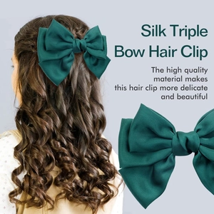 Detail of forest green triple-layer satin bow hair clip shown on model and close-up view