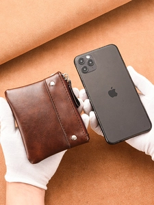 Brown vintage PU leather coin purse with zipper and rivets, compared with smartphone size