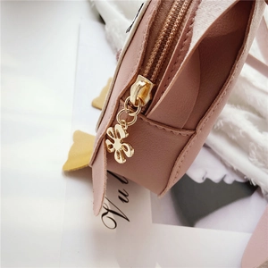 Close-up of pink penguin cartoon bag showing golden flower zipper and stitching details