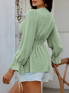 Détail du chemisier vert clair avec texture jacquard à pois et taille élastique