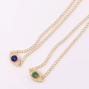 Macro detail of gold-plated tennis necklaces with evil eye pendants and sparkling zircons