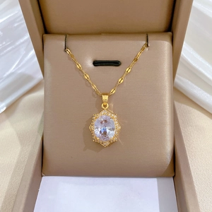 Macro view of gold-plated necklace featuring a large oval gem surrounded by small crystals
