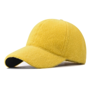 Detail view of the soft faux rabbit fur texture on a bright yellow baseball cap