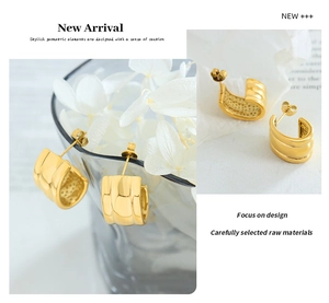 Detailed close-up of polished gold U-shape hoop earrings in minimalist style