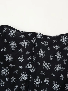Detailaufnahme des verdeckten Reißverschlusses am schwarzen Chiffon-Blumenkleid