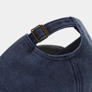 Detail of adjustable metal buckle and navy twill fabric on the vintage baseball cap