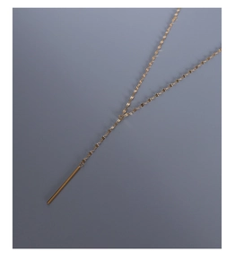 Vue détaillée d'un collier en Y doré de style français avec un pendentif barre minimaliste