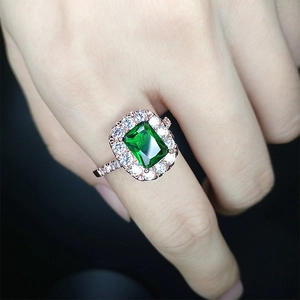 Close-up of rectangle emerald ring in rose gold with tiny diamonds on hand