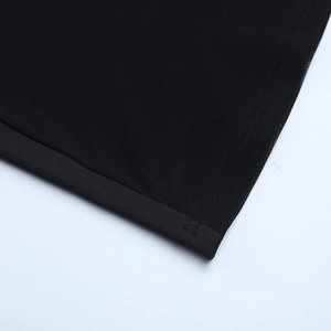 Gros plan détaillé sur le tissu en maille fine et la double couture soignée de la robe noire