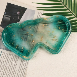 Green and white marble resin heart cloud tray with gold foil flakes on white surface