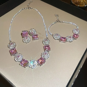 Detailed view of pink square gemstones and rose-shaped crystals in jewelry set