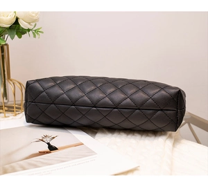 Gros plan du motif matelassé et des coutures sur un sac noir à chaîne avec décor intérieur