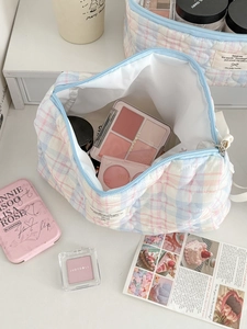 Detailed close-up of the pastel checkered quilted makeup bag with items inside
