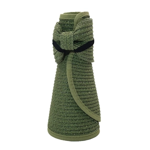 Detail of army green straw sun hat folded for storage with black elastic strap