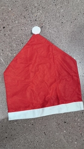 Close-up of red non-woven Christmas chair cover with white pompom and soft plush trim