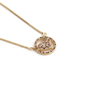 Golden box chain necklace with a round colorful zircon heart pendant on white background