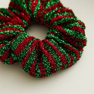 Close-up of glittery red and green striped Christmas scrunchie with metallic texture