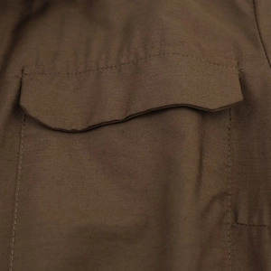 Detailed close-up of brown poplin dress pocket featuring clean stitching and cotton texture