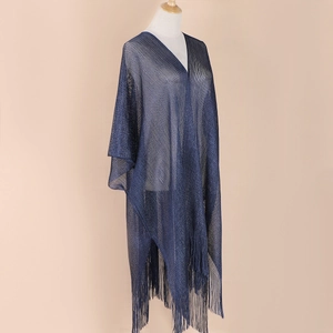 Detail of navy blue knit shawl featuring elegant long tassels and shimmering fabric texture