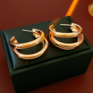 Dettaglio degli orecchini a doppio strato a forma di C in oro rosa su scatola nera