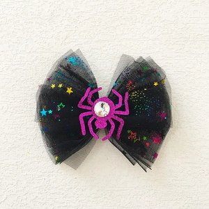 Close-up of Halloween bow hair clip with black mesh, sequins and pink glitter spider