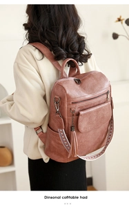 Lifestyle view of vintage red PU leather backpack with colorful woven strap and tassel