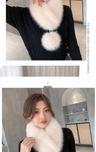 Detail of white faux fur scarf with plush pom-pom accessory on elegant knitwear