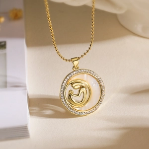 Close-up of mother and child necklace with gold pendant, zircons and shell inlay
