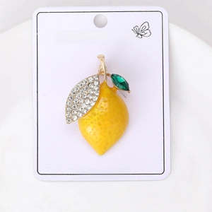 Detail of yellow enamel lemon brooch with white rhinestones on a white jewelry card