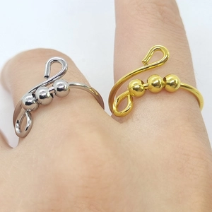 Detail of adjustable gold and silver stainless steel rings with three spinning beads
