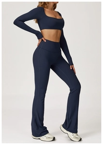 Detalle de conjunto de yoga azul marino con top corto de manga larga y pantalones de campana