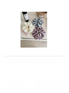Detailed view of oversized silk satin scrunchies measuring 22cm in glossy neutral tones