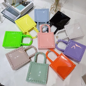 Flat lay of colorful PVC jelly mini bags with rivet details in a vibrant radial display