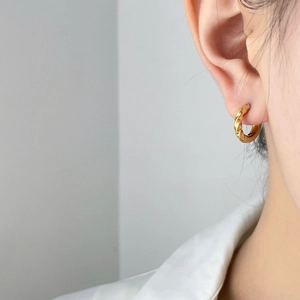 Abstract geometric twisted gold hoop earrings for women showing minimalist fashion style