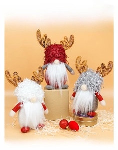 Three Christmas gnomes with reindeer antlers and long beards on a warm orange background