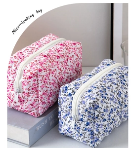Close-up of floral quilted cotton makeup bags with white zippers in two colorful patterns