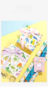 Detail showing cartoon gift wrapping paper rolls with unicorn card and gift box