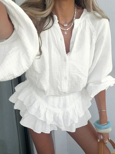 Dettaglio del set in mussola bianca con pizzo delicato su polsini e bordo della camicia