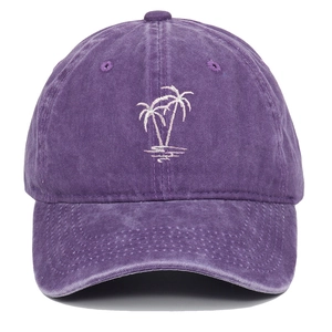 Close-up of white palm tree embroidery on a vintage washed purple cotton baseball cap