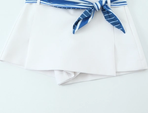 Close-up of white woven skort with blue and white striped tie belt detail