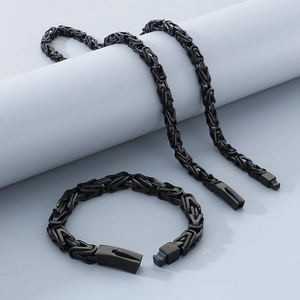 Detail of black Byzantine chain necklace and bracelet set on geometric props