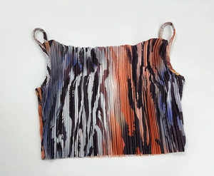 Detail of pleated camisole featuring orange and purple abstract tiger stripe print pattern