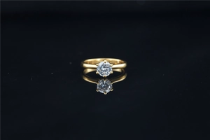 Detailed view of a gold six-prong setting with a round brilliant-cut moissanite stone