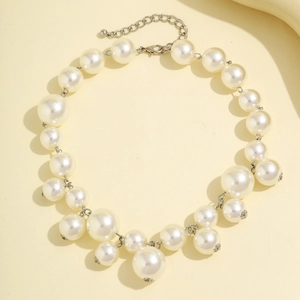 Detail of multi-layered faux pearl necklace with silver-tone lobster clasp and extension chain
