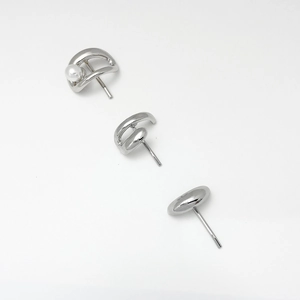 Macro shot of minimalist silver earring set featuring pearls and sleek curved metal designs