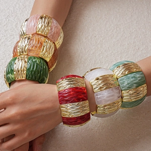 Detail of colorful acrylic resin pieces and textured gold metal segments on stretch bracelets