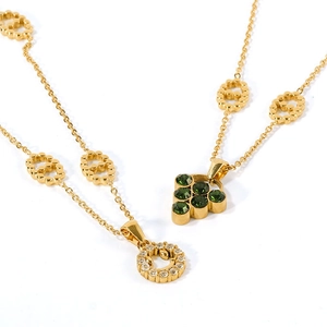 Gold layering necklace set with green gemstone and sparkling round diamond pendants