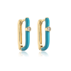 Close-up of geometric 18K gold earrings with blue enamel and sparkling zircon stone