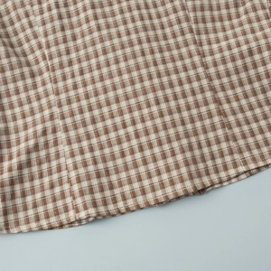 Close-up of brown and beige plaid cotton fabric texture with fine blue accents